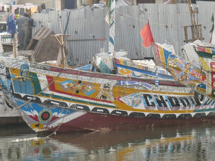 Une pirogue aux couleurs vives amarrée dans un port.